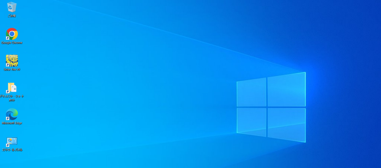 Windows 10の初期デスクトップ画面。左にごみ箱やGoogle Chrome、Microsoft Edgeなどのショートカットアイコンが縦に並び、右側に青いWindowsロゴの壁紙が広がっている。